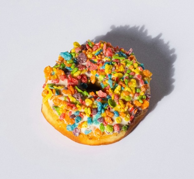 Donut topped with rainbow cereal on vanilla glaze.
